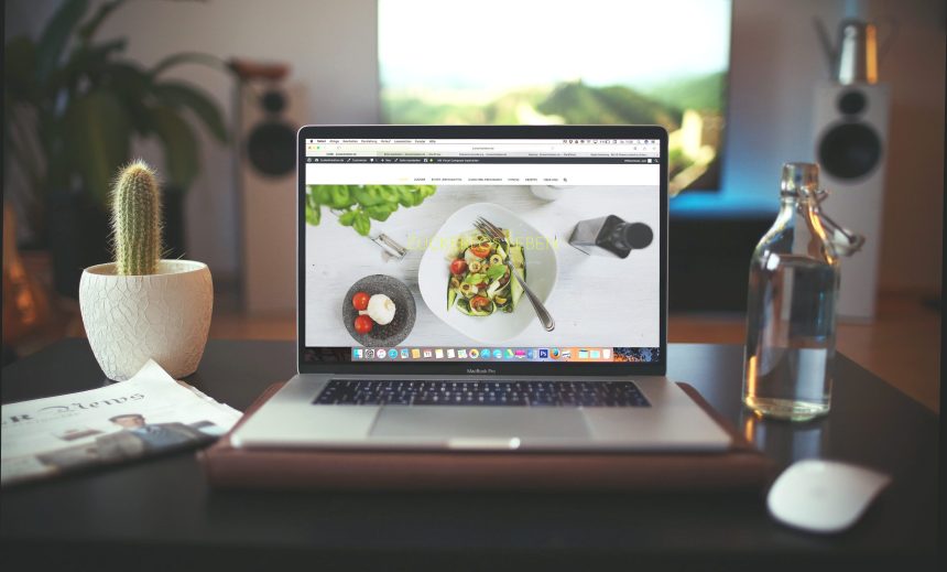 laptop sitting on a table with a website.