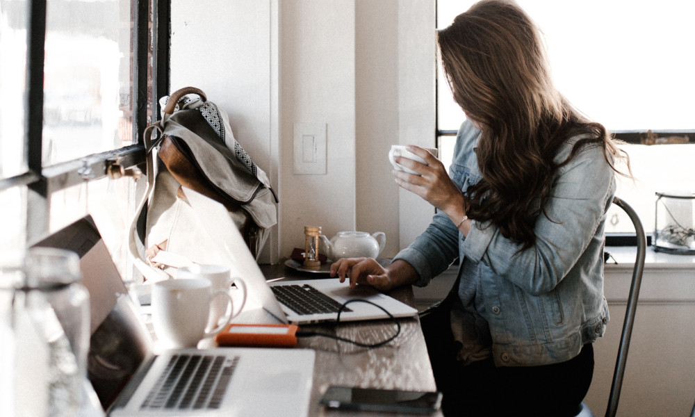 Woman Reading Tablet While Drinking Coffee -- Image by Andrew Neel